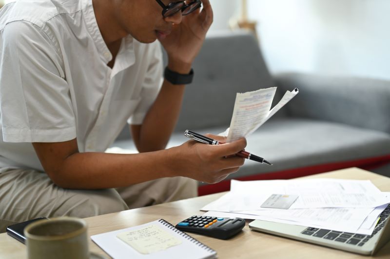 Image 9_800 man looking at receipts that he is holding