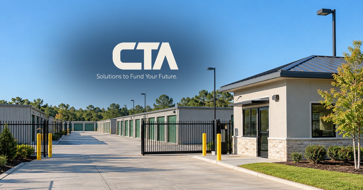 A modern self-storage facility with drive-up units, a security gate and a leasing office on a clear morning